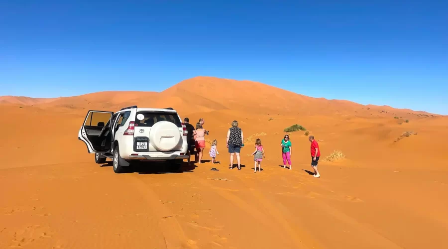 Desert-by-day Sahara desert by sunny day with family and white 4x4 vehicle during Tangier desert tour package