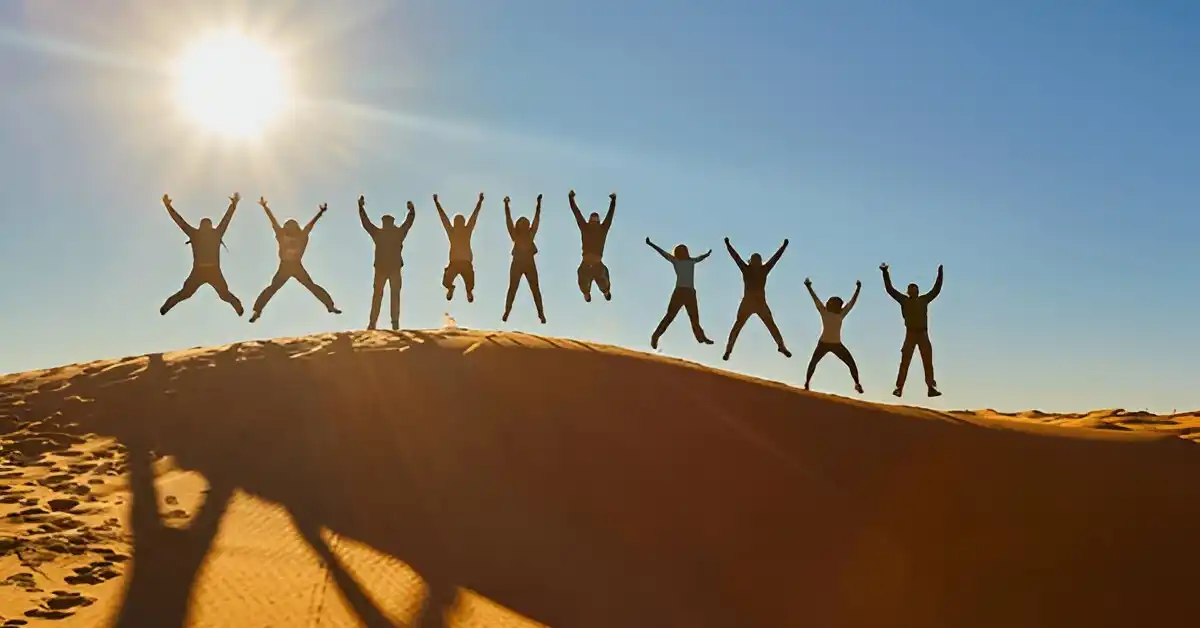 During Student tours, students jumping in the desert under sun