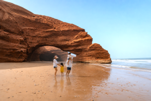 Familia disfrutando de la playa de Legzira durante un viaje privado por Marruecos.